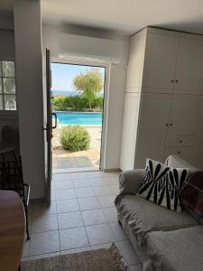 a living room with a couch and a view of a pool at ART BLUE Residence - Pool Access Apartment in Aghia Marina