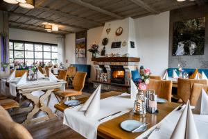 a restaurant with tables and chairs and a fireplace at Zur Kringelwies in Masburg