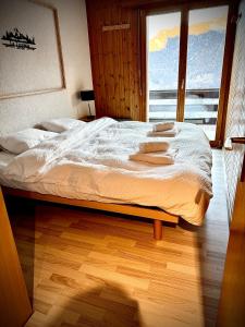 a large bed in a room with a window at Appartement au pied des télécabines in La Tzoumaz