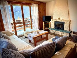 a living room with a couch and a fireplace at Appartement au pied des télécabines in La Tzoumaz