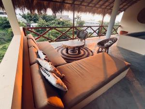 a couch on a porch with a table and chairs at Luxury Ocean View Villa in Brisas de Zicatela