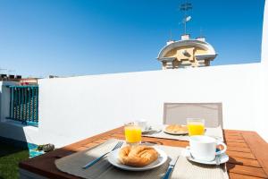 a table with two plates of food and two glasses of orange juice at Hommyhome Pozo Santo Penthouse in Seville