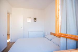 a bedroom with a white bed and a window at Casa Simona in Dervio