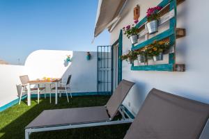 einen Balkon mit einem Tisch und Stühlen in einem Gebäude in der Unterkunft Hommyhome Pozo Santo Penthouse in Sevilla