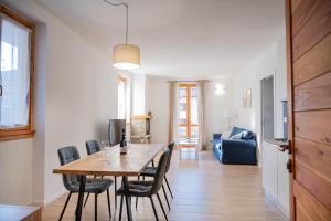 a dining room and living room with a table and chairs at Casa Simona in Dervio