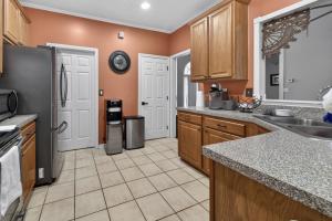 a kitchen with wooden cabinets and a black refrigerator at The Executive Suite in McDonough