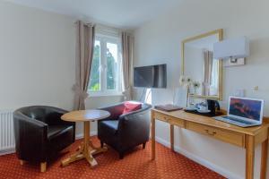 a room with a desk with a laptop and a chair at Wayford Bridge Inn Hotel in Stalham