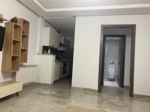 a room with a kitchen and a bathroom with a toilet at Lux app ain zaghouen in Tunis