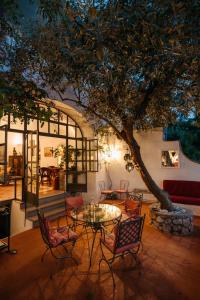 a patio with a table and chairs under a tree at Villa Guya in Capri
