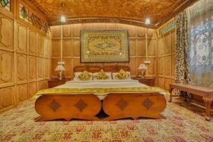 a bedroom with a large bed with wooden walls at Alexandra Houseboats in Srinagar