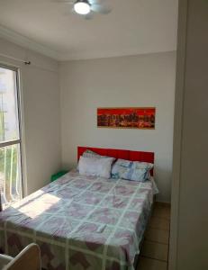 a bedroom with a bed with a red headboard at apartamento atras do shopping Iguatemi 2 quartos in Votorantim