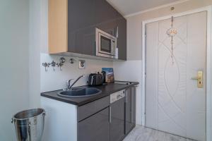 a small kitchen with a sink and a microwave at Andreas-Dirks-Straße 1, App 505 "Pralinchen" in Westerland