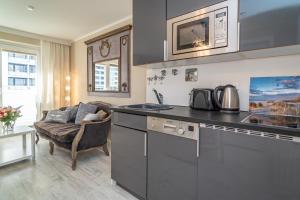 a kitchen with a sink and a couch in a room at Andreas-Dirks-Straße 1, App 505 "Pralinchen" in Westerland