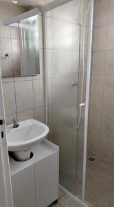 a white bathroom with a sink and a shower at apartamento atras do shopping Iguatemi 2 quartos in Votorantim