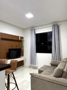 a living room with a couch and a television at Pousada & Flat Brandão - Canindé de São Francisco, SE in Canindé de São Francisco