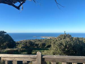 a view of the ocean from a wooden bench at CAMPING MONTE ORTU in Lumio
