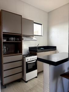a kitchen with a stove and a counter top at Pousada & Flat Brandão - Canindé de São Francisco, SE in Canindé de São Francisco