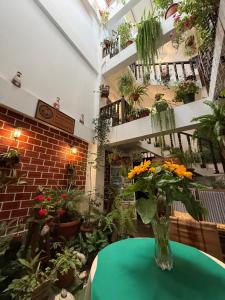 a vase of flowers on a table in a room with plants at Chachapoyas Backpackers Hostal Boutique in Chachapoyas