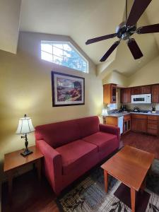 a living room with a red couch and a ceiling fan at Lighthouse Pointe Resort in Point Arena