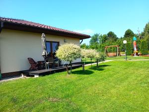 a house with a yard with a playground and umbrellas at luna in Gąski