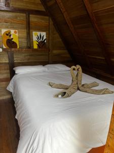 a bed with two stuffed animals on it at ALPHINA CABINS Qhapaq Ñan in Sahuayacu