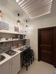 a kitchen with a sink and a counter with stools at Erbanova al Borgo Suite in Taranto