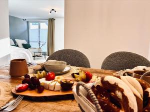 a wooden table with a plate of food on it at LYMA Suites - Apartment G2 in Immenstadt im Allgäu