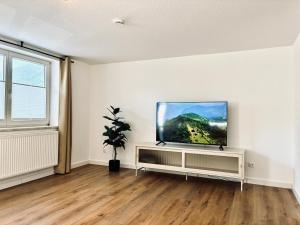 a living room with a flat screen tv on a white wall at LYMA Suites - Apartment G2 in Immenstadt im Allgäu