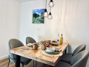a wooden table with chairs around it with a plate of food at LYMA Suites - Apartment G2 in Immenstadt im Allgäu +16 photos