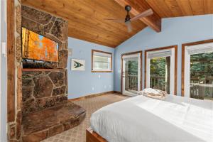 a bedroom with a bed and a stone fireplace at Abode at Alpine Retreat in Wilson