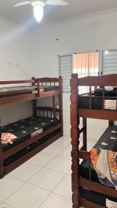 two bunk beds in a room with a ceiling at Casa de Praia com piscina in Mongaguá +19 photos