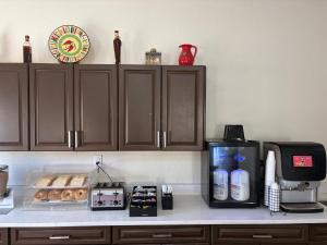 a kitchen counter with a coffee maker and a microwave at HomeTowne Studios by Red Roof Richmond, VA - W Broad St in Richmond