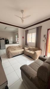 a living room with two beds and a couch at Casa de Praia com piscina in Mongaguá