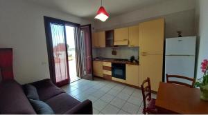 a kitchen with a couch and a refrigerator and a table at terrazza acquaviva in Marittima