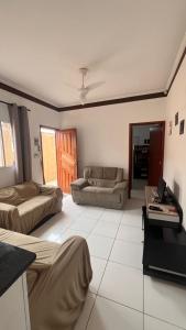 a living room with two beds and a couch at Casa de Praia com piscina in Mongaguá