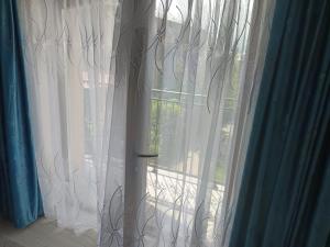 a window with white curtains in a room at casa Flav in Iaşi