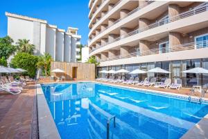 einen Pool in einem Hotel mit Stühlen und Sonnenschirmen in der Unterkunft Be Live Experience Costa Palma in Palma de Mallorca