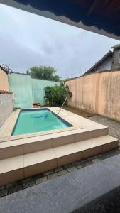 a swimming pool on the side of a building at Casa de Praia com piscina in Mongaguá