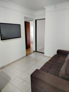 a living room with a couch and a flat screen tv at Ap 2quartos atras do shopping in Votorantim
