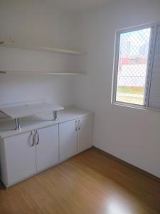a white kitchen with a sink and a window at Ap 2quartos atras do shopping in Votorantim