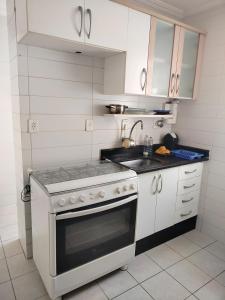 a white kitchen with a stove and a sink at Ap 2quartos atras do shopping in Votorantim