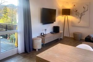 a living room with a tv on the wall at Ferienwohnung Bergzauber mit Balkon & Bergblick in Schliersee
