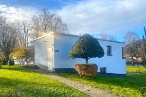 a small white house with a tree in front of it at Ferienwohnung Bergzauber mit Balkon & Bergblick in Schliersee