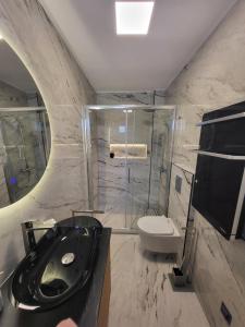 a bathroom with a black sink and a toilet at Apartments Aldo in Cavtat