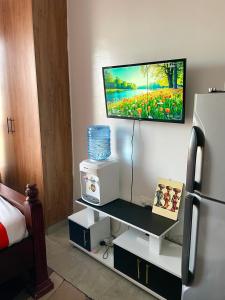 a room with a refrigerator and a table with a microwave at T-Homes in Nairobi