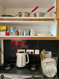 a kitchen counter with a stove with a tea kettle at T-Homes in Nairobi +7 photos