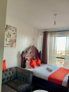 a bedroom with a bed and a chair and a window at T-Homes in Nairobi