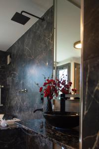a bathroom with a sink and a vase with red flowers at Vimaen Suites in La Cumbrecita +11 photos