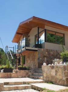 a house with a stone wall at Vimaen Suites in La Cumbrecita