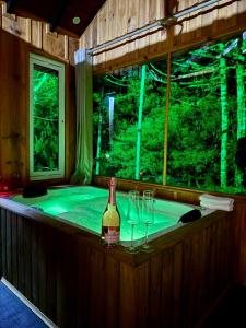 a bath tub with a bottle of wine and glasses at Cabanas Imbuia in Cambará